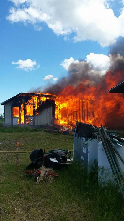 building in a field on fire