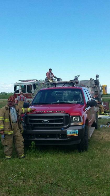 Firetruck in field with three firefighters 