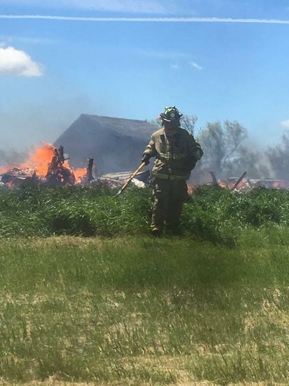 Firefighter standing in front of building on fire