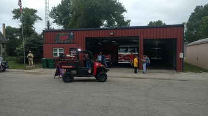 four wheeler driving by red fire department building