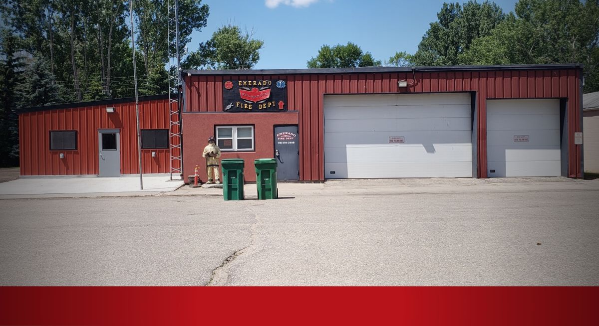 red building with white garage doors and black roof